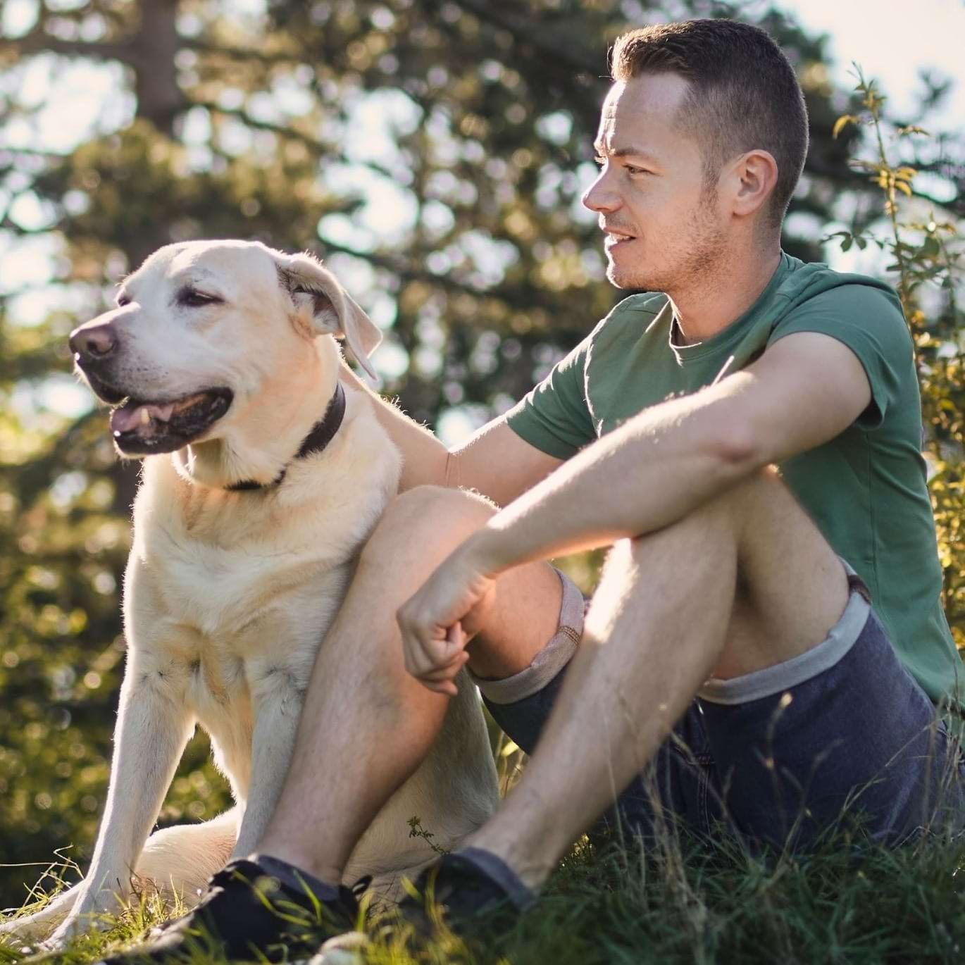 a man and a dog sitting in the grass